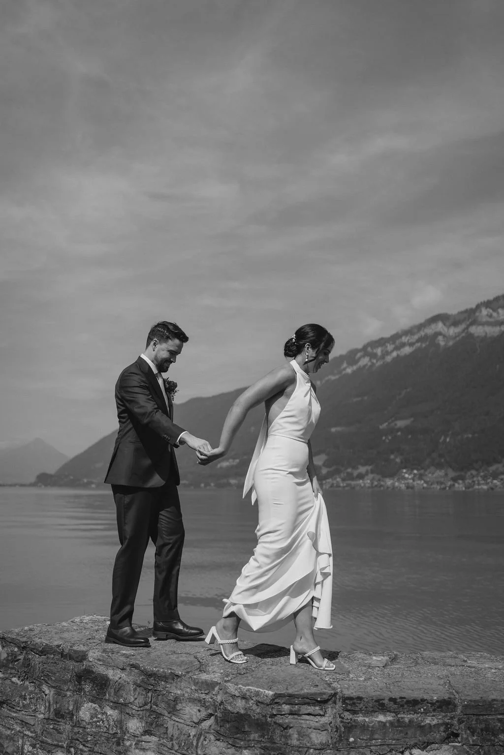 A black and white photo of a couple by the lake shore, Switzerland elopement