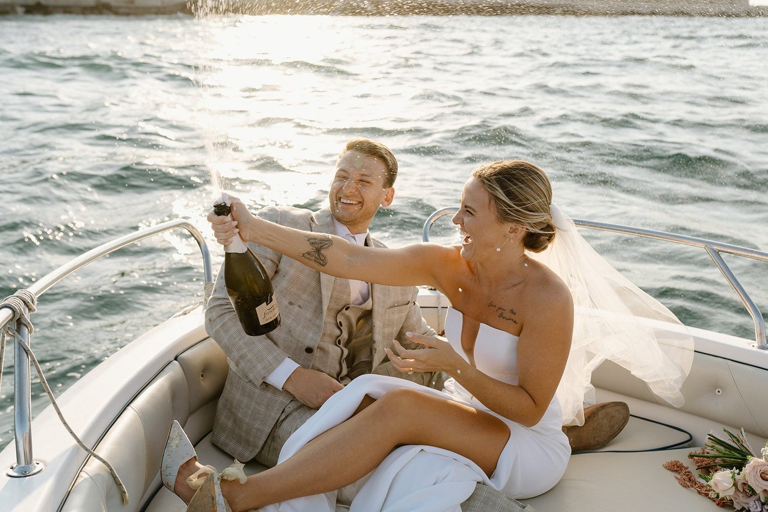 A couple toasting with champagne on a boat off the Apulia coast, elopement boat tour