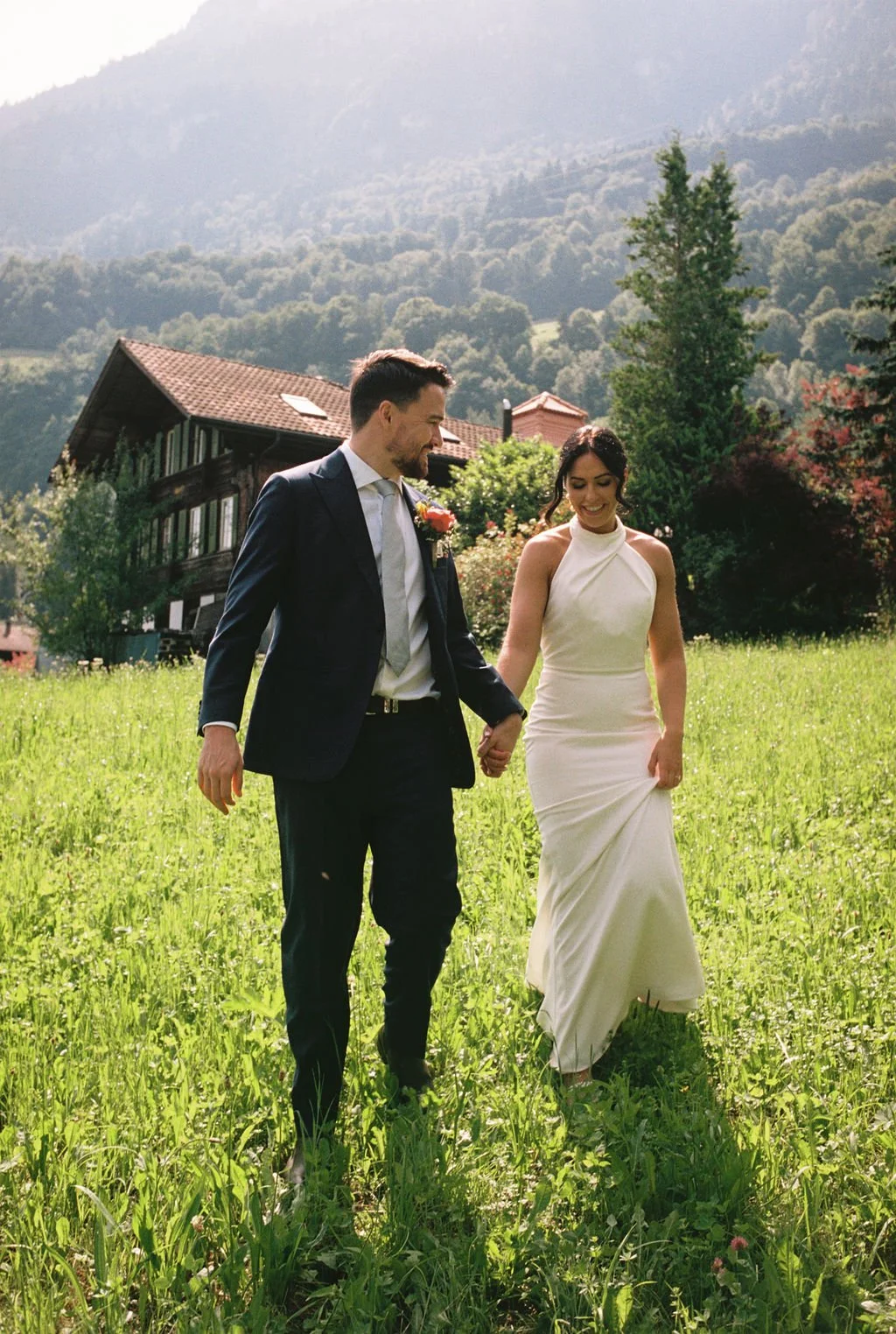 A couple walking hand in hand through an alpine meadow, Switzerland elopement
